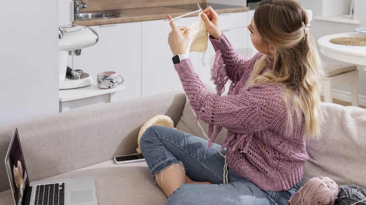 Young woman knitting while relaxing